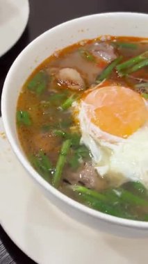 Bir insan limonu bir kase erişte çorbasına sıkıştırır, tadı narenciye ile artar. Yüksek kalite 4k görüntü