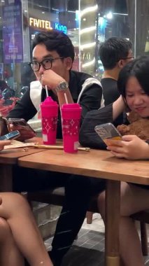 Cep telefonları bir kafede sohbet eden kadın arkadaş grubunda. Dört kadın bir kafede buluşup konuşuyor. Vietnam Da Nang 11.2025