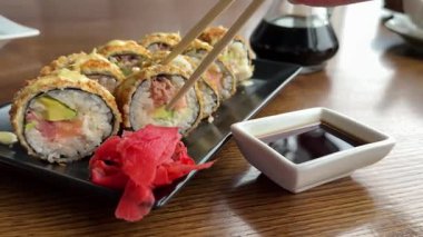 Soya soslu suşi ruloları ve yakın plan siyah tepside zencefil servis ediliyor. Japon mutfağı. Yüksek kalite 4k görüntü