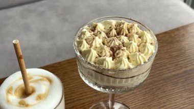 Kahve ve tiramisu masanın üstünde, masada bir fincan kahveyle birlikte. Yüksek kalite 4k görüntü