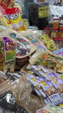 Yerel markaların sattığı geleneksel Vietnam pazarı kurutulmuş meyve, şeker, abur cubur ve renkli paketlerle dolu parlak tezgahlarda el yapımı tatlılar satıyordu. Vietnam Da Nang 11.2025