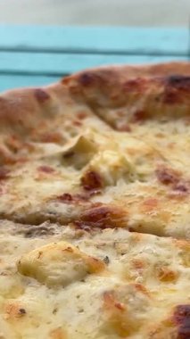 Siyah tabakta bir salam ve pastırmalı pizza döner, yakın plan. Dikey görüntü. Yüksek kalite 4k görüntü