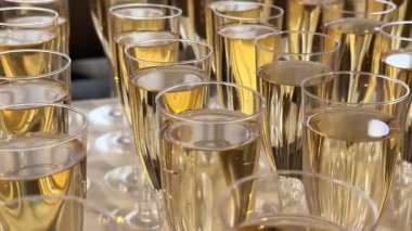 Şampanya tatma, şarap bardakları masanın üstünde, şık bir sofra kurma, şarap şişeden ve sürahide dökülüyor, köpüklü şarap köpükleri, atıştırmalıklar, insanlar aromayı kokluyor ve tadına bakıyorlar..