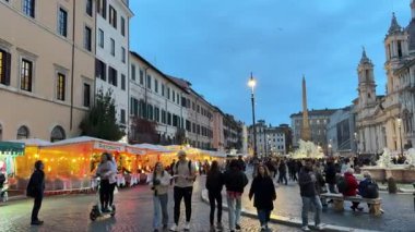 Roma 'daki Piazza Navona' da akşam sahnesinde ikonik fıskiyeler kalabalık sıcak ışıklar büyüleyici mimari ve dinamik atmosfer otantik İtalyan şehir yaşamını yakalar. Roma, İtalya 11.30. 2025