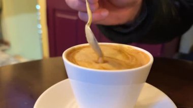 Kolajen tozunu kahveyle karıştırıyorum. Kadın fincana espresso kahvesiyle kolajen ekliyor. Yüksek kalite 4k görüntü
