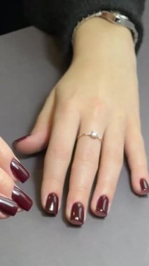 Güzellik salonunda manikürcü müşterinin yeni boyanmış tırnaklarını çekiyor, ışığı ayarlıyor ve sosyal medya reklamları ve güzellik içeriği için fotoğraf çekiyor.. 