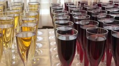 Büfede iki çeşit şampanya var: kırmızı ve beyaz, bir sürü sarı bardak. Yüksek kalite 4k görüntü