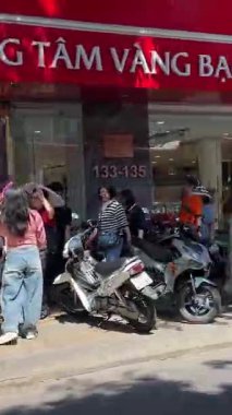 Kırmızı otobüs, Da Nang Vietnam 'da yerel mağazalar ve trafik ile yoğun caddelerde hareket ediyor. Motosiklet manzarasından yakalanan şehir yolculuğu sahnesi. Vietnam Da Nang 11.2025
