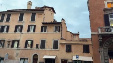 Roma sokaklarında güzel tarihi bir mimariyle yürürken kamera bulutları toplamaya doğru yükselirken huzurlu kasvetli şehir manzarasını ve seyahat sahnesini yakalıyor..