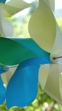 Ağaç dalından sarkan renkli kağıt fırıldaklar neşeli bir atmosfer yaratıyor. Yüksek kalite 4k görüntü