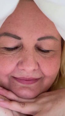 Gülümseyen mutlu kadın, gülümseyen, flört eden, yorgan gibi görünen, dişlek, dişlek, yatak odası, zevk kiracısı, neşe yatağı, pozitif dişçilik zevki. .