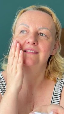 Koluna vücut losyonu ve cilt kremi süren mutlu bir kadın. Güzellik derisi kavramı. Yüksek kalite 4k görüntü