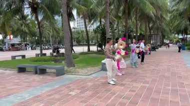 Dört Vietnamlı sanatçı, kültürel bir bayram kutlaması hazırlığı için pembe kurdeleler ve el zilleriyle sokak dansını prova ediyorlar. Vietnam Danang 12.18.2025