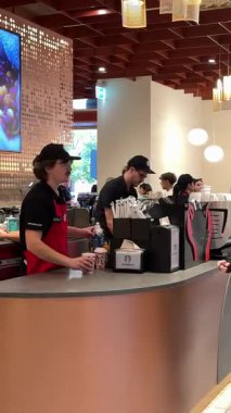 Sahneler Starbucks 'a gelen gençlerin rahatlamak için sırada bekleyip içki içtiğini ve kartlarla ödeme yaptığını gösteriyor. Sosyal ortamda rahatlık ve keyifli bir mola. Roma, İtalya 11.25.2025