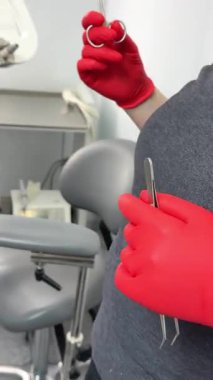 Kırmızı eldiven aletleri diş hekimi diş hekimi diş hekiminde kızıl saçlı bir kızın dişlerini tedavi ediyor. Diş hekimliği ve ağız temizliği. Yüksek kalite 4k görüntü