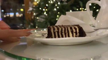 Çatalla servis edilen lezzetli çikolatalı pasta dilimi. Noel süslemeli ağaç