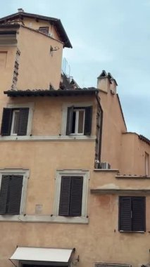 Roma sokaklarında güzel tarihi bir mimariyle yürürken kamera bulutları toplamaya doğru yükselirken huzurlu kasvetli şehir manzarasını ve seyahat sahnesini yakalıyor..