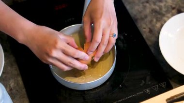 Yumurta sarısı tavaya düşer ve eller çatlar. Yeni yemek hazırlığını simgeler. 4K. Yüksek kalite 4k görüntü