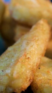 Kızarmış tabak içinde balık eti nugget 'ı. Dilimlenmiş ve pişirilmiş tostonlar. Dönüyor. Dikey görüntü. Yüksek kalite 4k görüntü