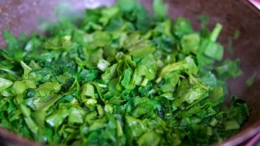 Ispanak yıkama ve haşlama süreci: erkeklerin ellerini suyun altında yıkamak, parçalara ayırmak, kızartma tavası atmak, karıştırmak, dondurmaya hazırlamak, ıspanaklı turta yapmak. Yüksek kalite 4k görüntü