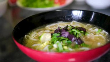 Geleneksel pho bo çorba hazırlama sıcak aromatik çorba pirinç vermicelli üzerine döküldü ardından taze otlar ve malzemeler lezzet dolu otantik bir sokak yemeği deneyimi yarattı.