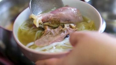 Geleneksel pho bo çorba hazırlama sıcak aromatik çorba pirinç vermicelli üzerine döküldü ardından taze otlar ve malzemeler lezzet dolu otantik bir sokak yemeği deneyimi yarattı.