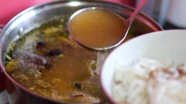 Pirinç vermicelli üzerine bir tencereden çorba dök. Yüksek kalite 4k görüntü