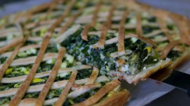 Yuvarlak bıçakla kesilmiş lezzetli bir ıspanaklı yumurta ve peynirli turta. Margherita pizza. Lezzetli Napolitan Pizza Margherita 'nın yakın çekimi. Pizzayı dilimleyen bir insan..