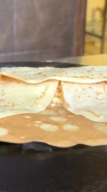 Aşçı lezzetli kahvaltı için sıcak yüzeyde küçük yuvarlak gözlemeler hazırlıyor. Yemek blogu, yemek tarifi fikirleri ve tatlı aile anları için mükemmel. Yüksek kalite 4k görüntü