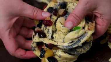 Haşhaş tohumlu çörekler pişirmek, şefin elleri hamuru salyangoz şekline sokmak. Ev yapımı aromatik hamur işleri, dolgulu salyangoz çöreği, ön manzara, makro. Yüksek kalite 4k görüntü