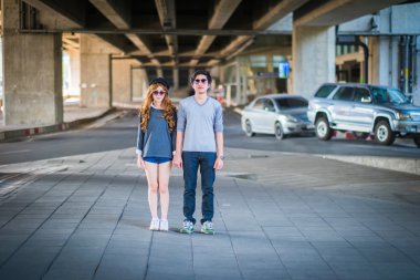 Çift ayakta poz. Ve güneş gözlüğü, arka plan 