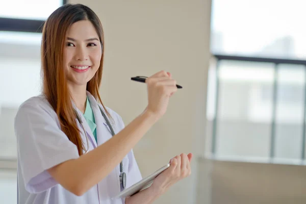 Happy smiling young beautiful female doctor showing blank area f — Stock Photo, Image