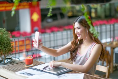 Güzel genç bayan yaz terasında oturup tablet ile