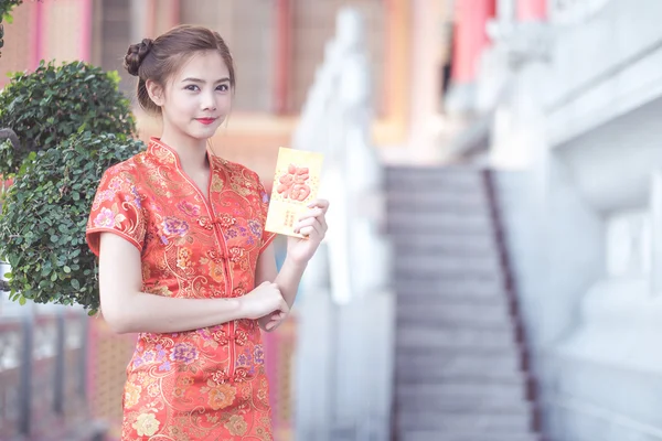 A mulher asiática em vestido chinês segurando couplet 'Happ — Fotografia de Stock