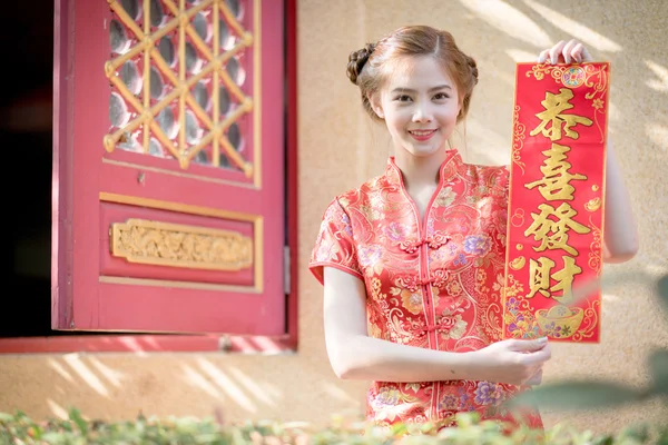A mulher asiática em vestido chinês segurando couplet 'Lucrativ — Fotografia de Stock