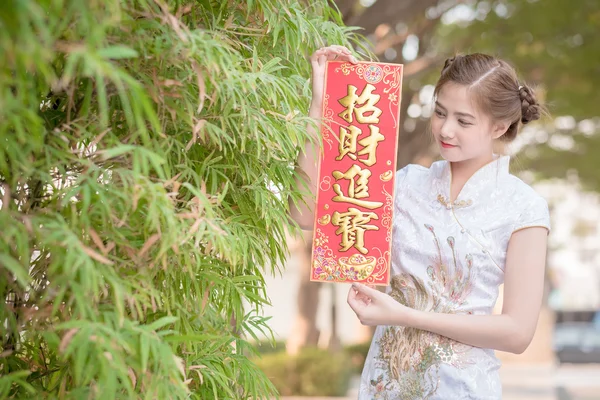 Азиатка в китайском платье держит двойной строн — стоковое фото