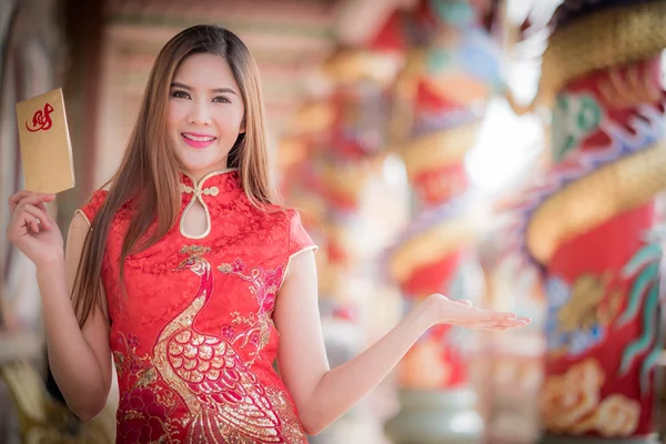 A mulher asiática em vestido chinês segurando couplet 'Lucrativ — Fotografia de Stock