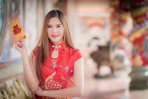 Китаянка одевается традиционно Чхонсам и держит красный envel — стоковое фото
