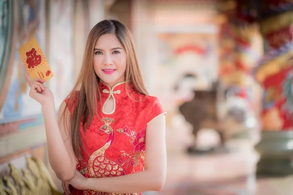 A mulher chinesa vestido tradicional cheongsam e segurar envel vermelho — Fotografia de Stock