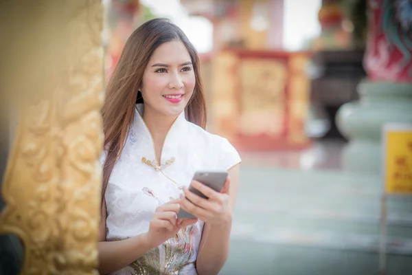 Asiatische Chinesin in traditionellem Chinesisch und Telefon halten — Stockfoto