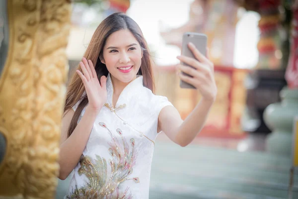Asiatische Chinesin in traditionellem Chinesisch und Telefon halten — Stockfoto