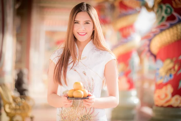 Asian Chinese woman in Traditional Chinese holding orange pay re — Stock Photo, Image