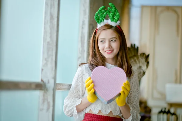 Little girl with winter clothes holding  gift box — Stock Photo, Image