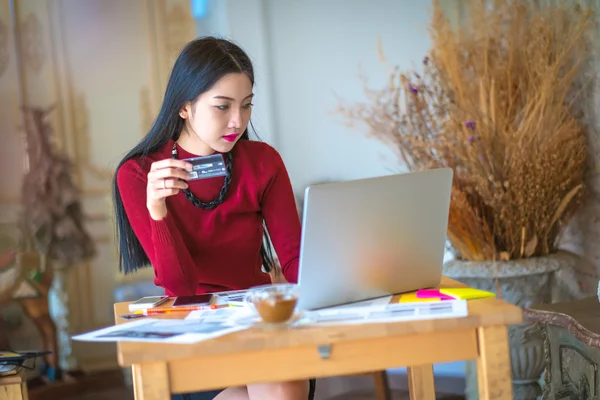 La linda mujer joven de compras en línea con su tarjeta de crédito y un — Foto de Stock