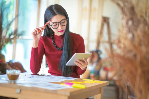O yazarak bir masada oturan çalışan genç kadın girişimci