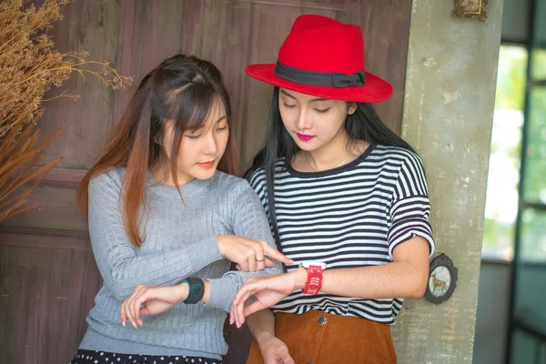 Dos jóvenes y tecnología. Mujer joven asombrada con smartwatch usi — Foto de Stock