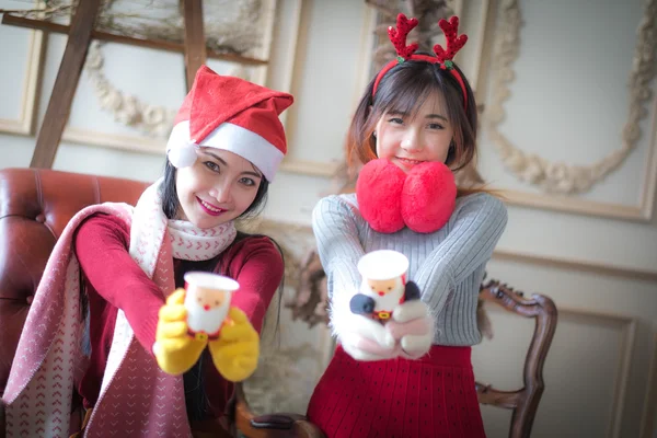 Two beautiful elegant women in winter clothing And hot drinks co — Stock Photo, Image