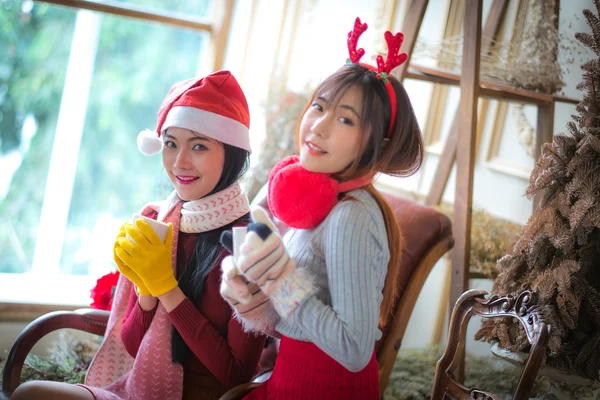 Two beautiful elegant women in winter clothing And hot drinks co — Stock Photo, Image