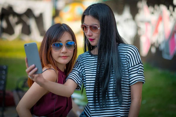Twee tienermeisjes vrienden in hipster outfit.at buiten het park — Stockfoto