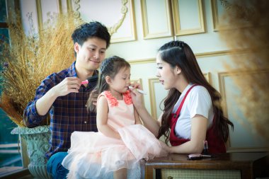 Baba, anne ve kızı makyaj ile oynamak. 